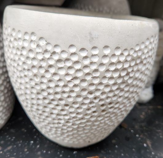 A Dart Dot Planter Cement 17x17cm with a lot of holes in it.