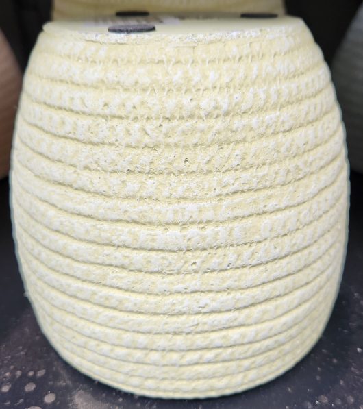 A white ceramic Dart Weave Egg Green M 19x18cm sitting on a table.