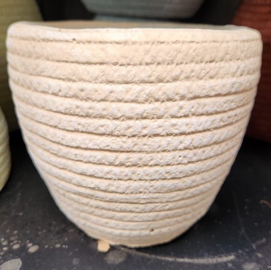 A Dart Weave Egg Pink M 19x18cm ceramic pot sitting on a shelf.