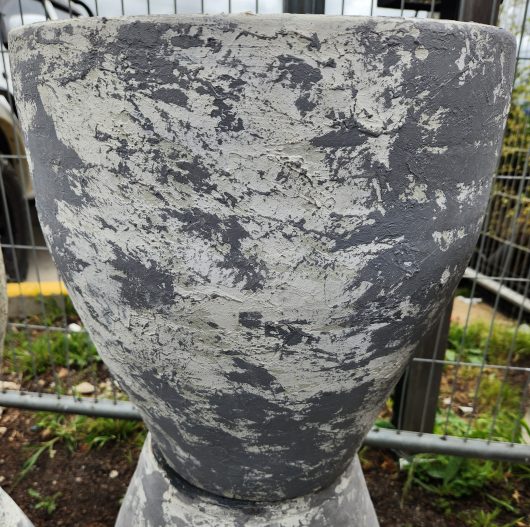 A Stoneware Tall Villa Grey and White M 42x42cm planter sitting on a fence.