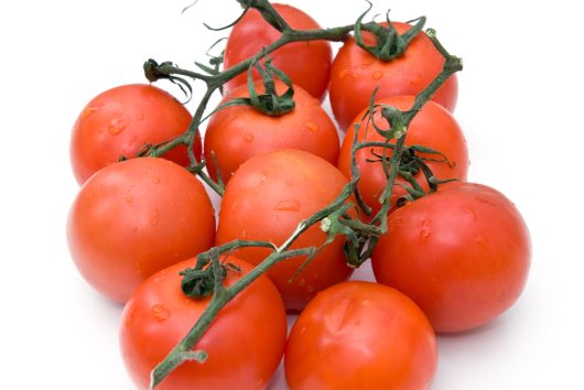 A cluster of ripe red tomatoes, evocative of the vivid colors characteristic of the Tomato 'Adelaide Festival' 4" Pot, rests serenely on a white surface.