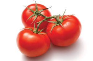 Three ripe red tomatoes attached to a green vine rest on a white background, showcasing the effortless beauty that can solve garden design problems.