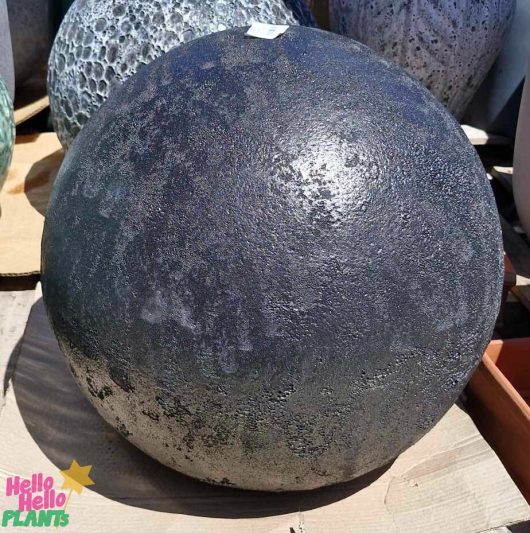 The Sorrento Decorative Ball Black 50x50cm is on display, its large round textured surface featuring contrasting lighter tones, surrounded by similar objects.