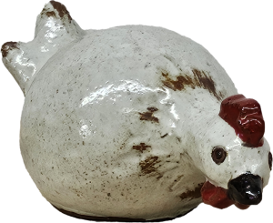 A charming ceramic chicken sculpture with a white body, brown speckles, and a red comb and wattle evokes rustic decor. Its elegant profile mirrors that of the classic Portica Dog Rust Decor L 19x14x23cm.